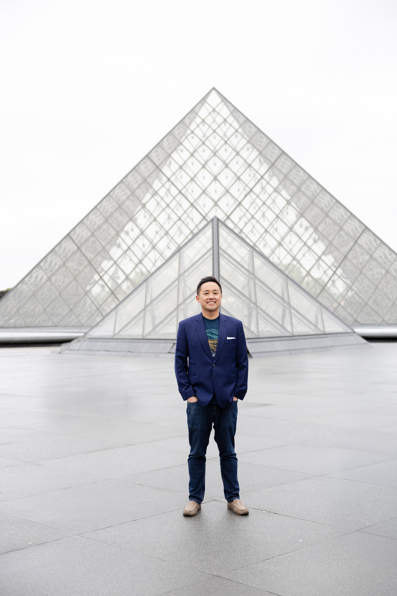 John Liu standing in front of the Louvre Pyramid